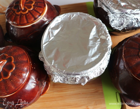 Закрыть горшочки крышками или фольгой. Поместить горшочки в духовку на решетку на средний уровень. Дать прогреться немного горшочкам с мясом, через 5–7 минут температуру уменьшить до 120°C. Готовится мясо в духовке примерно 3 часа 10 минут.