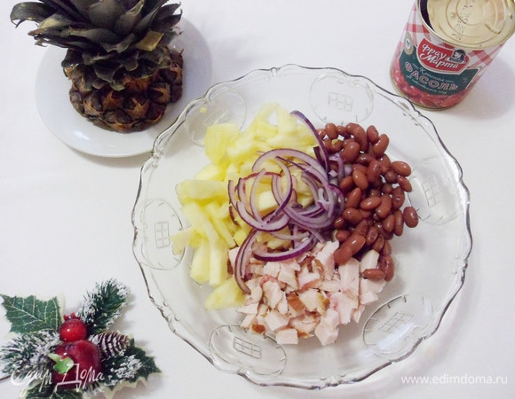 Нарезанную кусочками отварную грудку, ананас, красный лук и фасоль выложить в салатник.