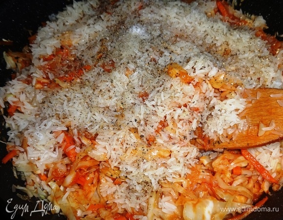 Выложить рис к овощам в сковороду. Посолить, поперчить, добавить молотые семена кориандра (я перемолола в мельнице).