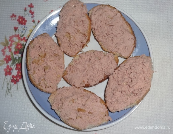 Намазать кусочки батона мясным паштетом. По возможности используйте паштет от проверенного производителя, а еще лучше — домашний паштет: прокрутите в мясорубке любое вареное или жареное мясо, соедините его со сметаной, сливочным маслом или майонезом. Я использовала покупной мясной паштет. Раньше в качестве этого производителя я была уверена, но сейчас качество резко упало: паштет оказался пересоленным и содержал слишком много желатина. К сожалению, под рукой готового мяса не было, пришлось делать с ним.
