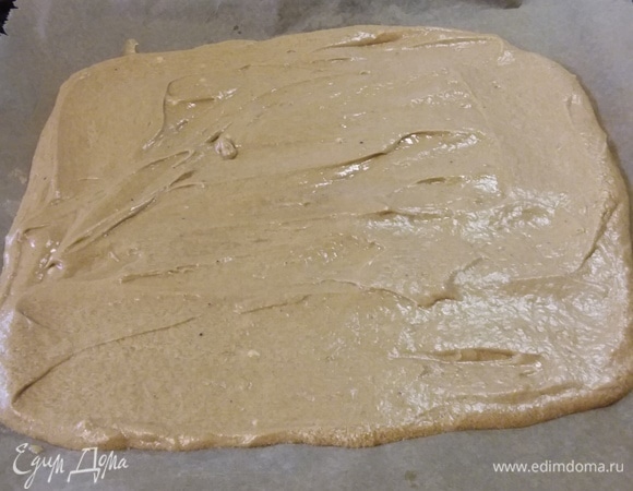 Выложить тесто на противень, покрытый пергаментной бумагой, разровнять. Выпекать в заранее разогретой до 180°C духовке 10–12 минут. Подготовить чистое полотенце, слегка посыпанное сахаром. Достать противень, аккуратно переложить корж на полотенце (бумагой наверх), снять бумагу. С помощью полотенца свернуть корж в рулет и в таком виде остудить.