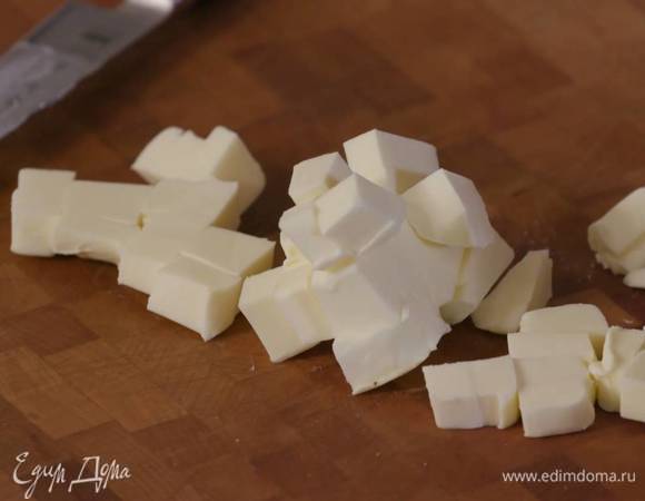 Предварительно охлажденное сливочное масло нарезать маленькими кубиками.