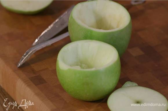У яблок срезать верхнюю часть с веточкой, чтобы получились крышечки, затем вырезать сердцевину с косточками, не прорезая бока, сбрызнуть яблоки внутри лимонным соком.