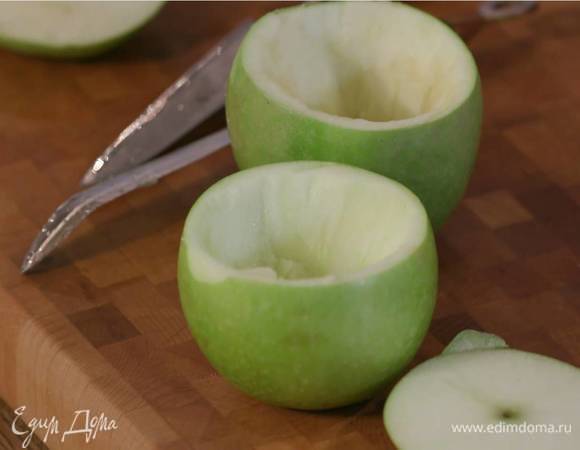 У яблок срезать верхнюю часть с веточкой, чтобы получились крышечки, затем вырезать сердцевину с косточками, не прорезая бока, сбрызнуть яблоки внутри лимонным соком.
