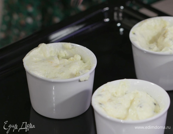 Керамические формы смазать сливочным маслом, присыпать внутри оставшимся сахаром и выложить в них белковую массу, заполняя формы на 3/4 объема.