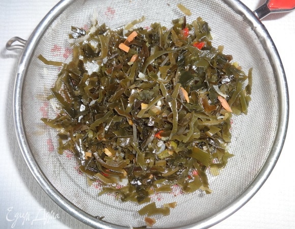 Салат из морской капусты откинуть на сито и дать полностью стечь маринаду.