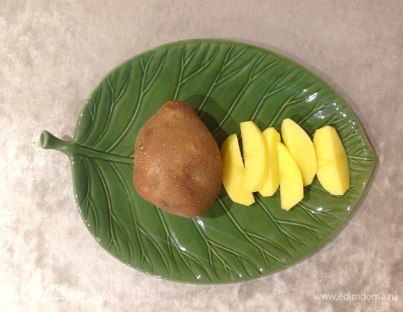 Включаю духовку на 200°C. Чищу картофель, нарезаю большими дольками.