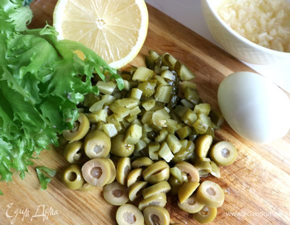 Очистить яйцо, дать ему полностью остыть. Нарезать оливки, фаршированные лимоном, колечками, маринованные огурцы — мелкими кубиками.