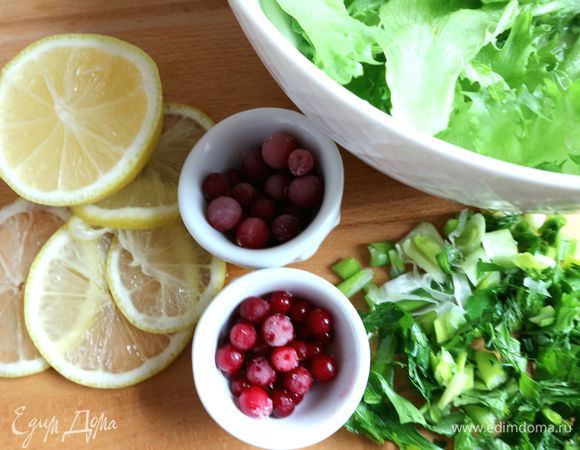 Нарезать мелко (наискосок) зеленый лук, петрушку, укроп. Лимон нарезать тонкими кружочками, затем разрезать их пополам. Клюкву, бруснику разморозить. Добавить лук, петрушку и укроп в салат. Добавить майонез, перемешать.