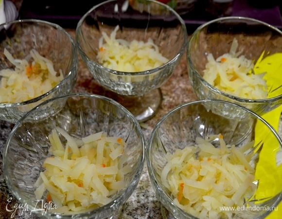 Салат готовим сразу в креманках, чтобы он оставался нежным и воздушным. Ни в коем случае не прижимайте ингредиенты друг к другу. Пусть слои «дышат», так все пропитается. Первый слой — тертая картошка.