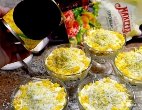 Девятый слой — майонез. Десятый слой — тертое яйцо. Украсить салат по кругу кукурузой и грецким орехом.
