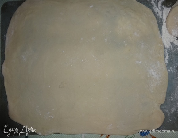 Тесто достать из холодильника. Разделить на 2 неравных части. Большую часть раскатать в тонкий пласт по размеру формы с прибавками на бортики.