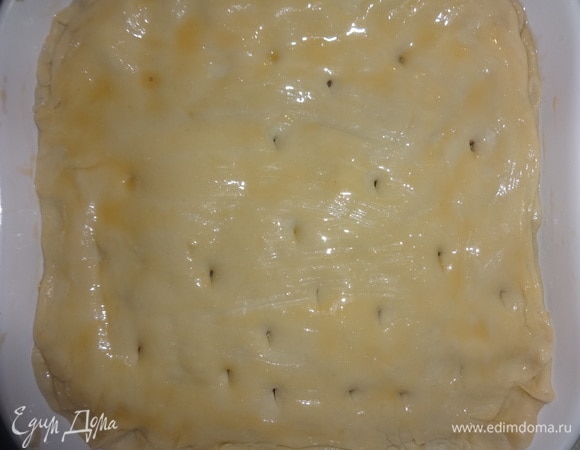 Раскатать второй кусок теста и накрыть им начинку, скрепляя с нижним пластом теста. В отложенное для смазки пирога яйцо добавить масло, перемешать. Смазать верх пирога, сделать несколько проколов на поверхности для выхода пара.