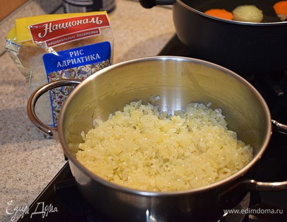 Добавить в сотейник рис «Адриатика» ТМ «Националь». Обжарить рис, помешивая, около минуты.