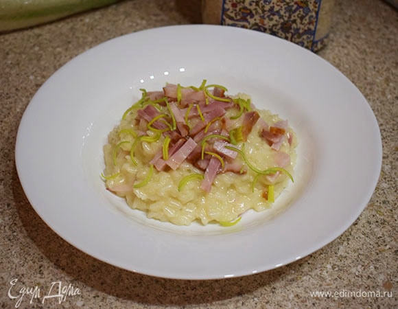 Разложить ризотто по тарелкам, сверху выложить оставшуюся грудинку и посыпать зеленым луком.