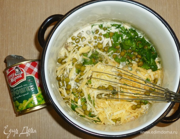 В тесто добавить тертый сыр, горошек (без жидкости), рубленую зелень, пропущенный через пресс чеснок, соль и перец. Перемешать.