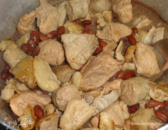 В кастрюлю с фасолью выложить обжаренные мясные продукты: свинину, бекон, колбаски. Продолжать тушить все вместе под закрытой крышкой. Если необходимо, долить немного воды.