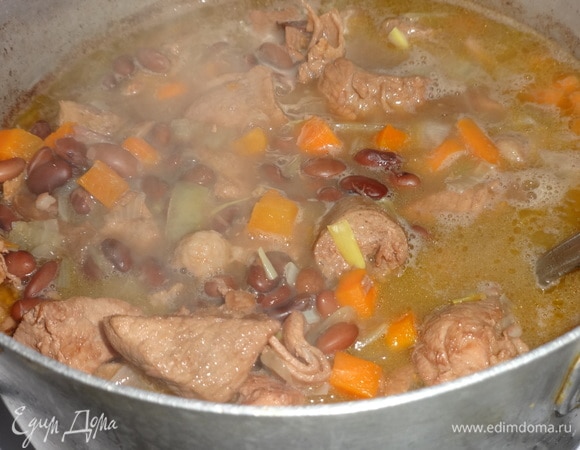Когда свинина и фасоль станут достаточно мягкими, выложить в кастрюлю обжаренные лук с морковью.