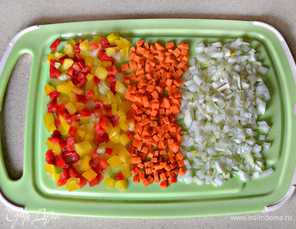 Перец, лук и морковь нарежьте небольшими кубиками. Затем пассеруйте около 3 минут на растительном масле вначале лук, затем добавьте морковь и еще через 3 минуты — перец. Слегка посолите и поперчите овощи.