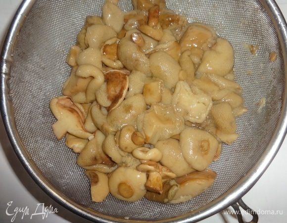 Маринованные грибы откинуть на сито. Также промыть под проточной водой, дать воде стечь. У меня домашние маринованные грибочки, привезенные родственниками из Тамбова. Если попадаются очень крупные кусочки грибов, можно их нарезать помельче.