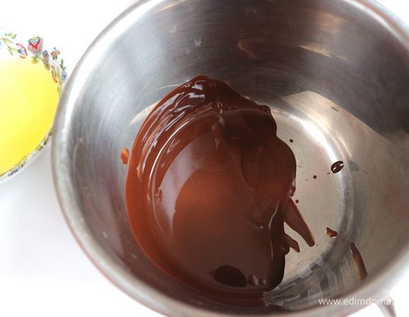 Дно разъемной формы и борта слегка смазать сливочным маслом. Застелить дно и борта бумагой для выпечки. Духовку разогреть до 180°C. Горький шоколад с содержанием какао 78% ( 50 г) разломать на маленькие кусочки, растопить на водяной бане. Помешивать. Вынуть сотейник с шоколадом, немного остудить.