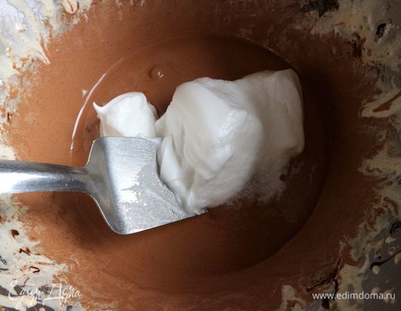 Выложить белки частями на взбитые желтки. Сначала немного, аккуратно перемешать снизу вверх лопаткой.