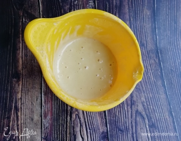 Отдельно соединим муку с разрыхлителем. Во взбитые яйца добавляем воду, а затем — сухие ингредиенты. Перемешиваем и оставляем, прикрыв, на 15–20 минут.