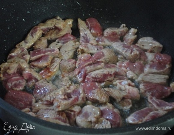 В казане или сотейнике разогреть растительное масло и обжарить в нем мясо, пока не выпарится вода. Кусочки должны слегка поджариться.