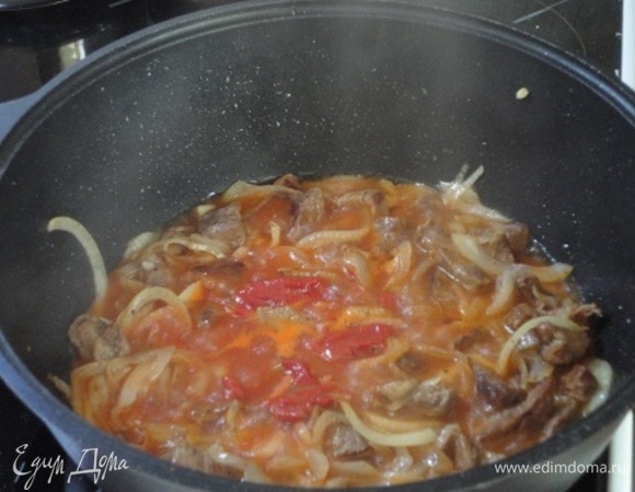 Добавляем томатную пасту со стаканом кипятка (в сезон помидоров — 3–4 свежих плода, которые очищаем от кожицы, нарезаем кубиками). Кипяток можно не добавлять. Убавляем огонь, накрываем крышкой и тушим до готовности. Немного солим.