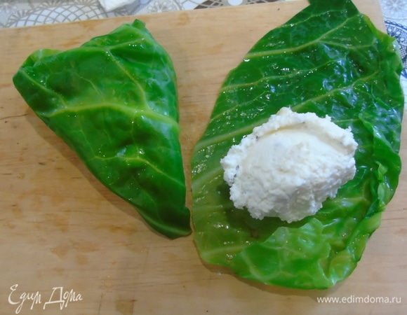 Выкладываем немного начинки на капустный лист. Можно на целый, а можно разрезать лист пополам.
