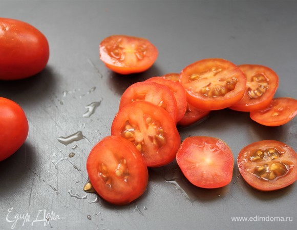 Нарезать слайсами помидоры черри.