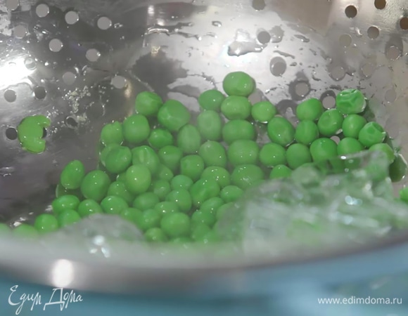 Зеленый горошек опустить на несколько минут в кипящую воду, затем откинуть на дуршлаг и обдать ледяной водой или поместить на лед.