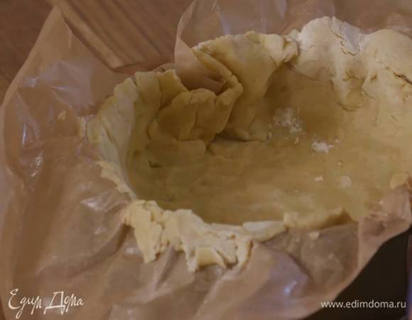 Тесто поместить между двумя листами для выпечки, смазанными оставшимся маслом, раскатать скалкой в тонкий пласт и выложить в разъемную форму, затем верхний лист бумаги снять и отправить форму с тестом ненадолго в морозильник.