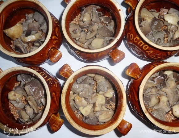 Выложить грибы вместе с жидкостью в горшочки поверх гречки, посолить.