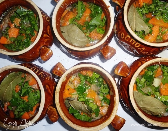 Положить зелень в горшочки и налить воду или бульон. Положить в каждый горшочек по половинке лаврового листа.