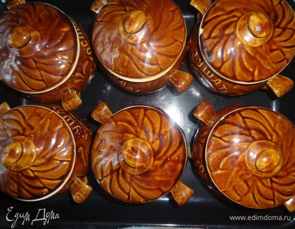 В каждый горшочек положить по кусочку сливочного масла. Накрыть горшочки крышками, поставить на противень и поместить в холодную духовку. Разогреть ее до 180°C и с этого момента вести отсчет времени: готовить примерно 45–50 минут.