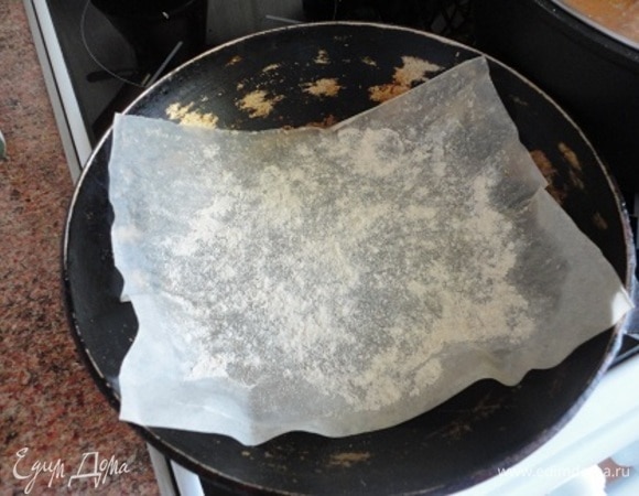 Когда видим, что хлеб готов, включаем духовку на разогрев на максимум вместе с металлической или каменной основой, на которой будете выпекать хлеб. У меня для этого есть чудесная, испытанная временем сковорода. Горячую сковороду я осторожно застилаю кусочком бумаги, посыпанной ржаной мукой.