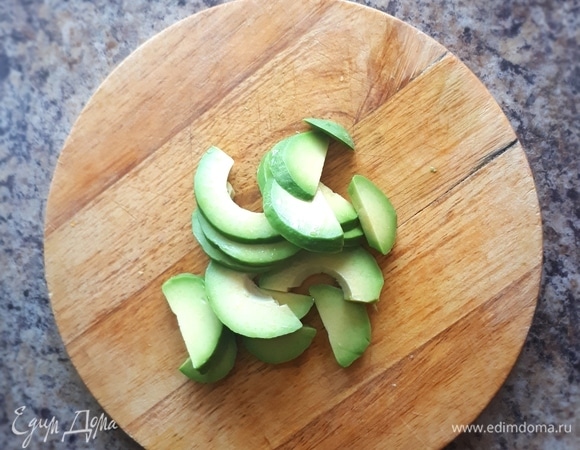 Авокадо разрежем пополам, снимем кожуру и нарежем дольками. Сбрызнем лимонным соком.