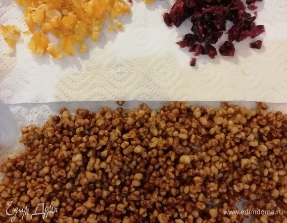 Выкладываем воздушную гречку на салфетку. Мелко нарезаем высушенные цукаты и вяленую клюкву.