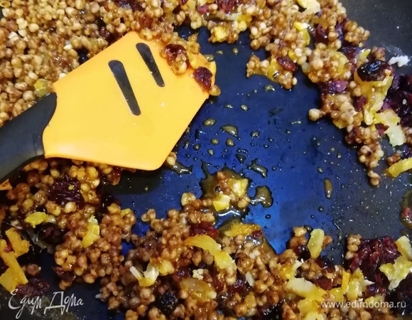 Добавляем в карамель попкорн из гречки и цукаты. Быстро перемешиваем и выкладываем на силикиновый коврик.