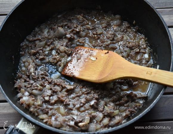 Влить вино и тушить до выпаривания алкоголя.