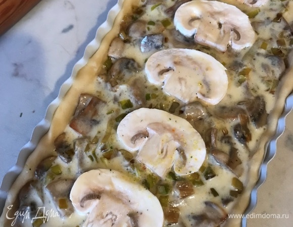 Выложить сверху тонкие слайсы шампиньона. Духовку разогреть до 180°C. Выпекать 15–20 минут до золотистой корочки.