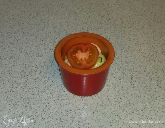 Горшочек, в котором будем запекать рыбное филе, смазываем оливковым маслом. Затем выкладываем на дно горшочка кружок помидора, затем — рыбное филе, затем — нарезанный кружочками лук и еще один кружок помидора.