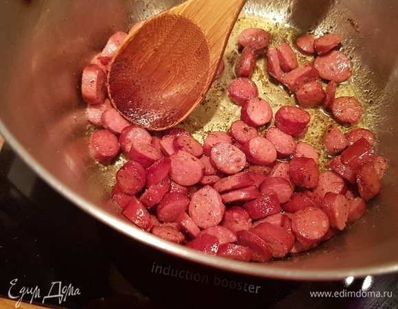 Далее добавляем колбаски и обжариваем примерно 2 минуты.
