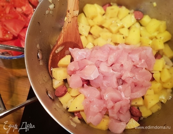 После обжарки лука добавляем куриное филе, перемешиваем, оставляем на огне на 2 минуты и затем добавляем фасоль и нарезанный помидор.