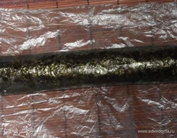 Ролл провернуть два раза по листу нори. То есть использовать только половину нори. Это нужно, чтобы слой нори в конце не оказался слишком толстым. Таких роллов сделать 4. Немного приплюснуть их в овалы.