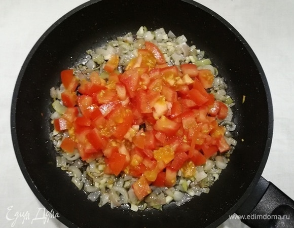 Добавляем нарезанные помидоры и жарим все вместе 5 минут.