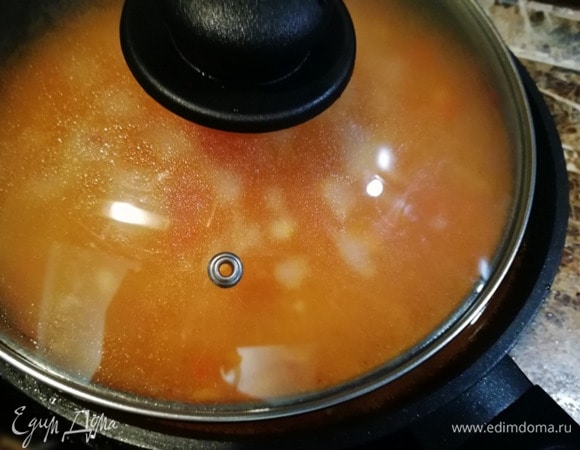 Доводим содержимое сковороды до кипения, убавляем мощность конфорки до средней и томим под плотно закрытой крышкой 20 минут.