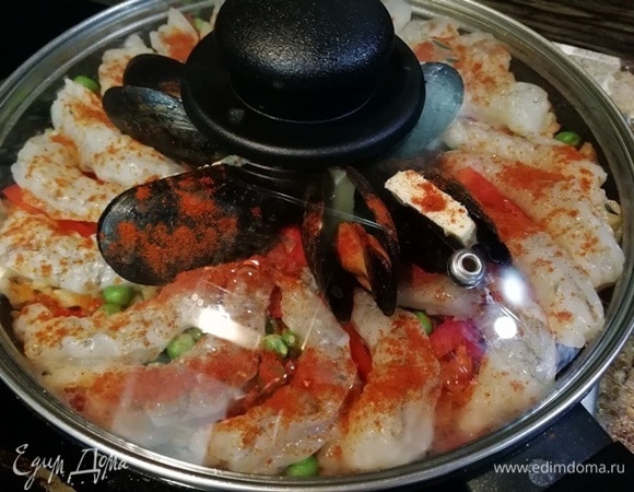 Накрываем сковороду крышкой и оставляем на плите на 10 минут. Затем сковороду снимаем с плиты и оставляем паэлью под закрытой крышкой еще на 10 минут.