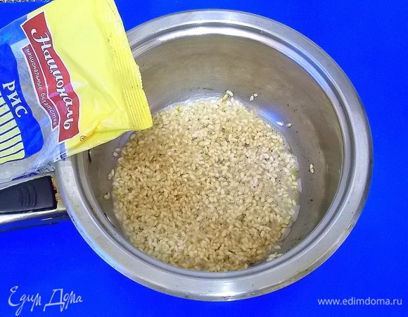 Сливочное масло растопить в сковороде и всыпать рис. Обжарить его на среднем огне до слегка золотистого цвета. Это позволит запечатать крахмал внутри и не стать впоследствии массе вязкой.